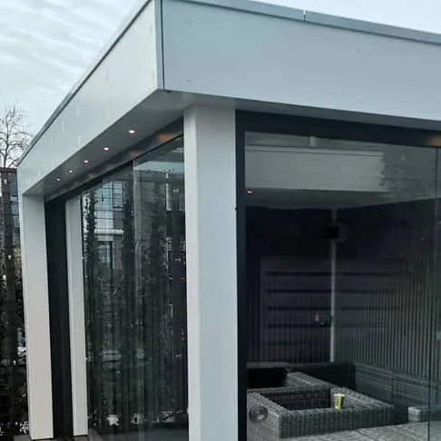 Grijs buitenverblijf met glazen schuifwand, inbouwspots en een loungeset op een vlonder