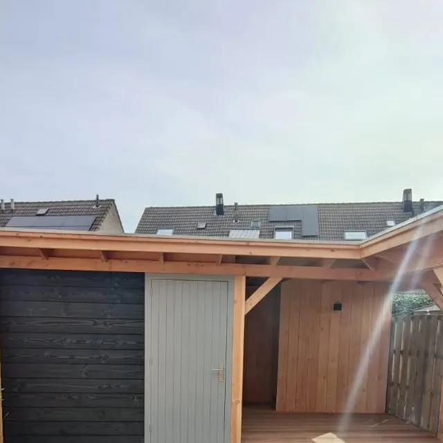 Modern buitenverblijf met antraciet wanden, glazen schuifpui en een loungehoek